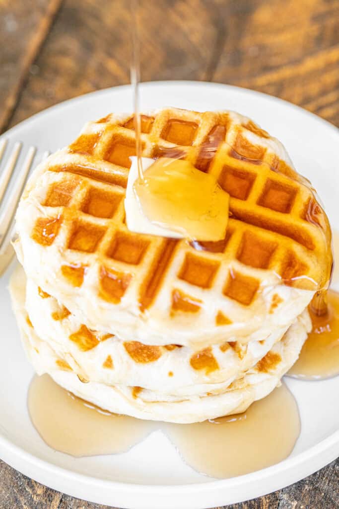 plate of waffles topped with syrup and butter