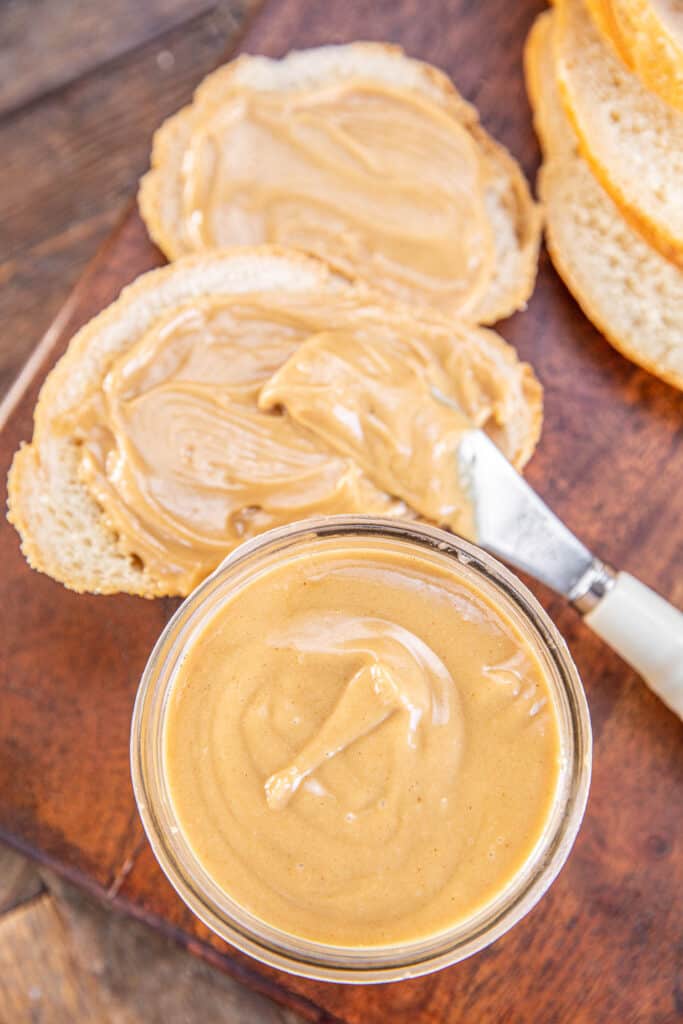 jar of peanut butter with bread in the background