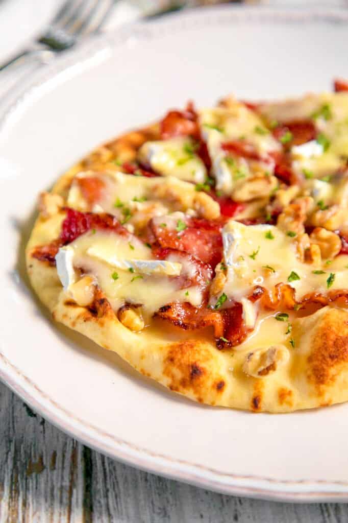 naan flatbread topped with brie and bacon