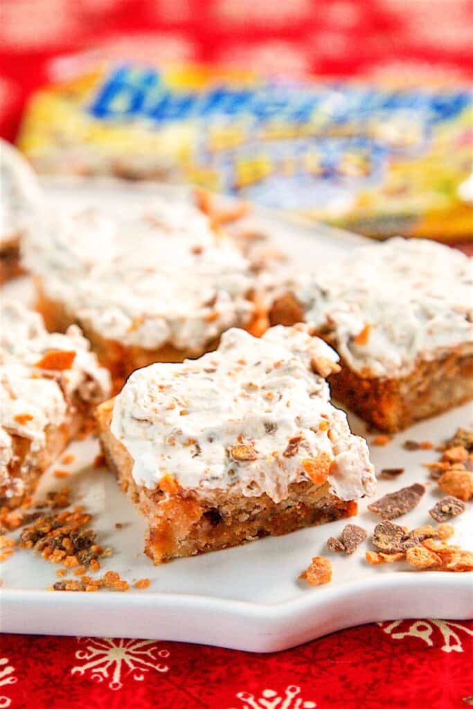 platter of butterfinger shortbread bars with whipped cream topping