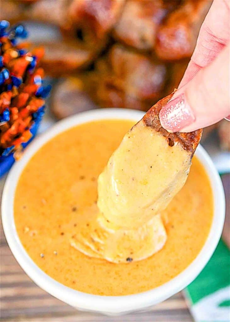 dipping sausage in beer cheese sauce