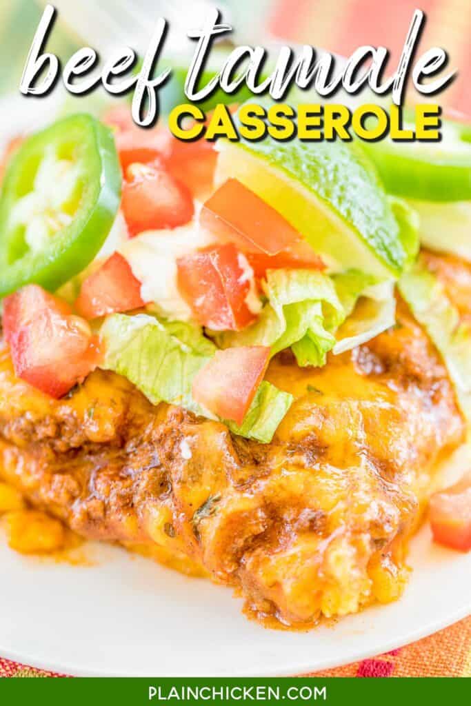 slice of beef tamale casserole on a plate topped with lettuce tomatoes and lime