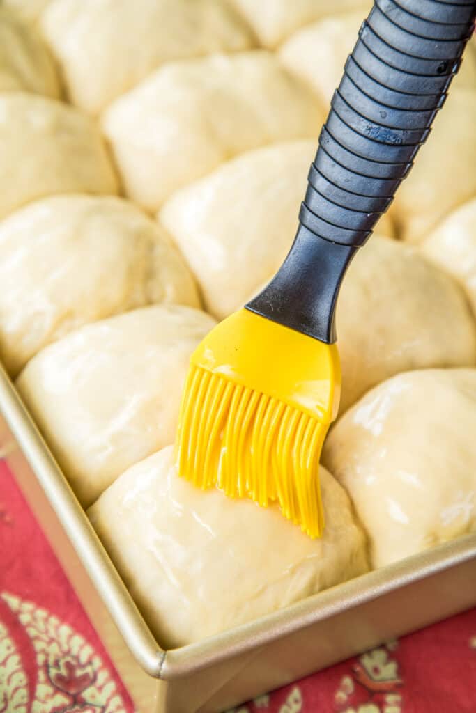 brushing unbaked rolls with butter