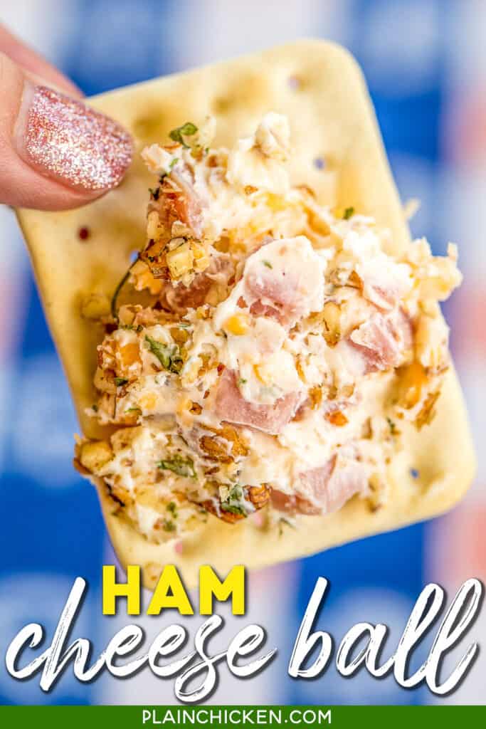holding a crack with ham & cheese spread on it