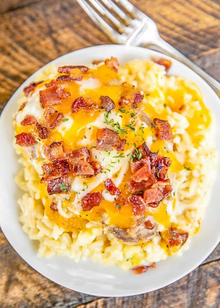 plate of pork chops covered in cheese and bacon