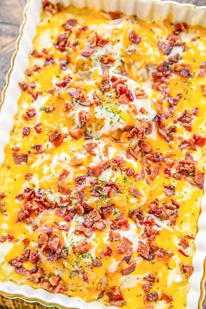 baking dish of pork chops smothered in cheese and bacon