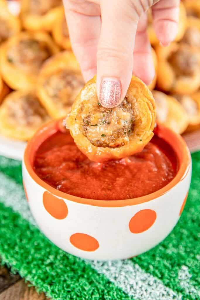 dipping biscuit bite into pizza sauce