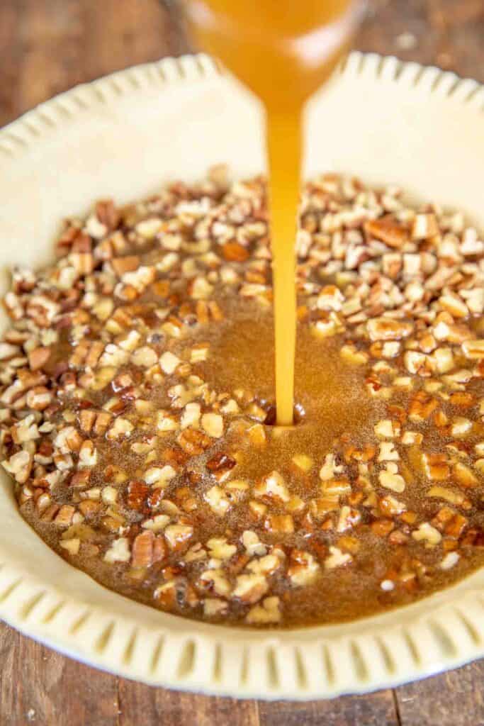 pouring pecan filling into pie crust