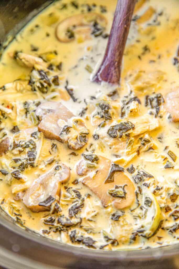 crockpot of spinach and artichoke soup with mushrooms and chicken