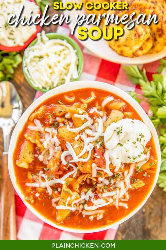 bowl of tomato, chicken and pasta soup topped with cheese