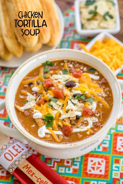Chicken Tortilla Soup - the secret ingredient makes all the difference!! Ready in about 15 minutes. Can also make this in the slow cooker. Freeze leftovers for a quick lunch or dinner later!! Rotisserie chicken, refried beans, black beans, diced tomatoes and green chiles, taco seasoning, corn and chicken broth. Top soup with cheese, tortilla chips and sour cream. Serve with some cornbread for an easy weeknight meal that the whole family will enjoy! Everyone loved this easy Mexican recipe!!