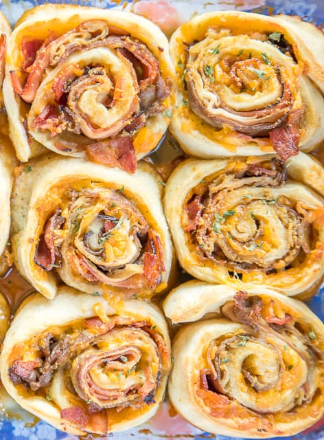 Club Sandwich Party Rolls -  so good! ham, turkey, roast beef, bacon and cheddar are rolled up (cinnamon bun style!) in soft, fluffy pizza dough. Then they’re drizzled with a brown sugar dijon glaze and baked until golden, gooey, and crispy. They are seriously so good!! I could eat them everyday!! Great for tailgating, brunch, lunch, dinner and parties! Always the first thing to go!