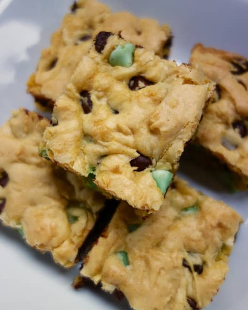 Chocolate Mint Cookie Bars - easy cake mix cookie bars. Ready to bake in minutes. Everyone LOVES this easy dessert recipe!! Only 6 ingredients! Cake mix, eggs, vanilla, butter, milk and mint chocolate chips. Whip up a batch today!!