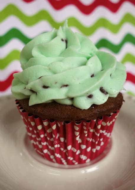 Mint Chocolate Chip Cupcakes - easy chocolate cupcakes topped with a homemade mint chocolate chip buttercream! Cake mix, butter, mint extract, powdered sugar, whipping cream, green food coloring and mini chocolate chips. Great for parties! #cupcakes #mintchocolate #stpatricksday 