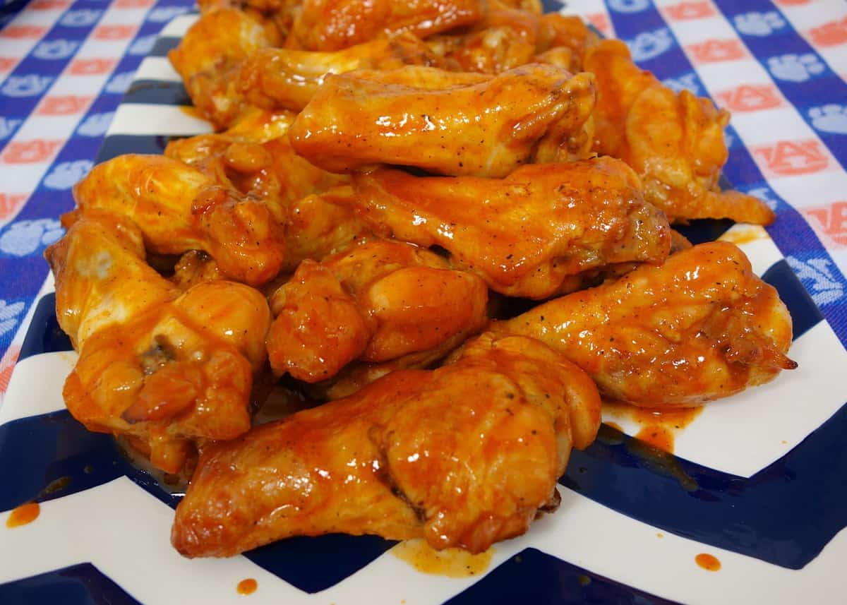 Beer Brined Chicken Wings - CRAZY delicious wings!! Baked not fried!!! Chicken wings marinated in beer, brown sugar, and salt. Bake on a rack in the oven and toss in buffalo wing sauce. Serve with ranch, bleu cheese and celery sticks. Great for parties! #chicken #tailgating #chickenwings #buffalowings