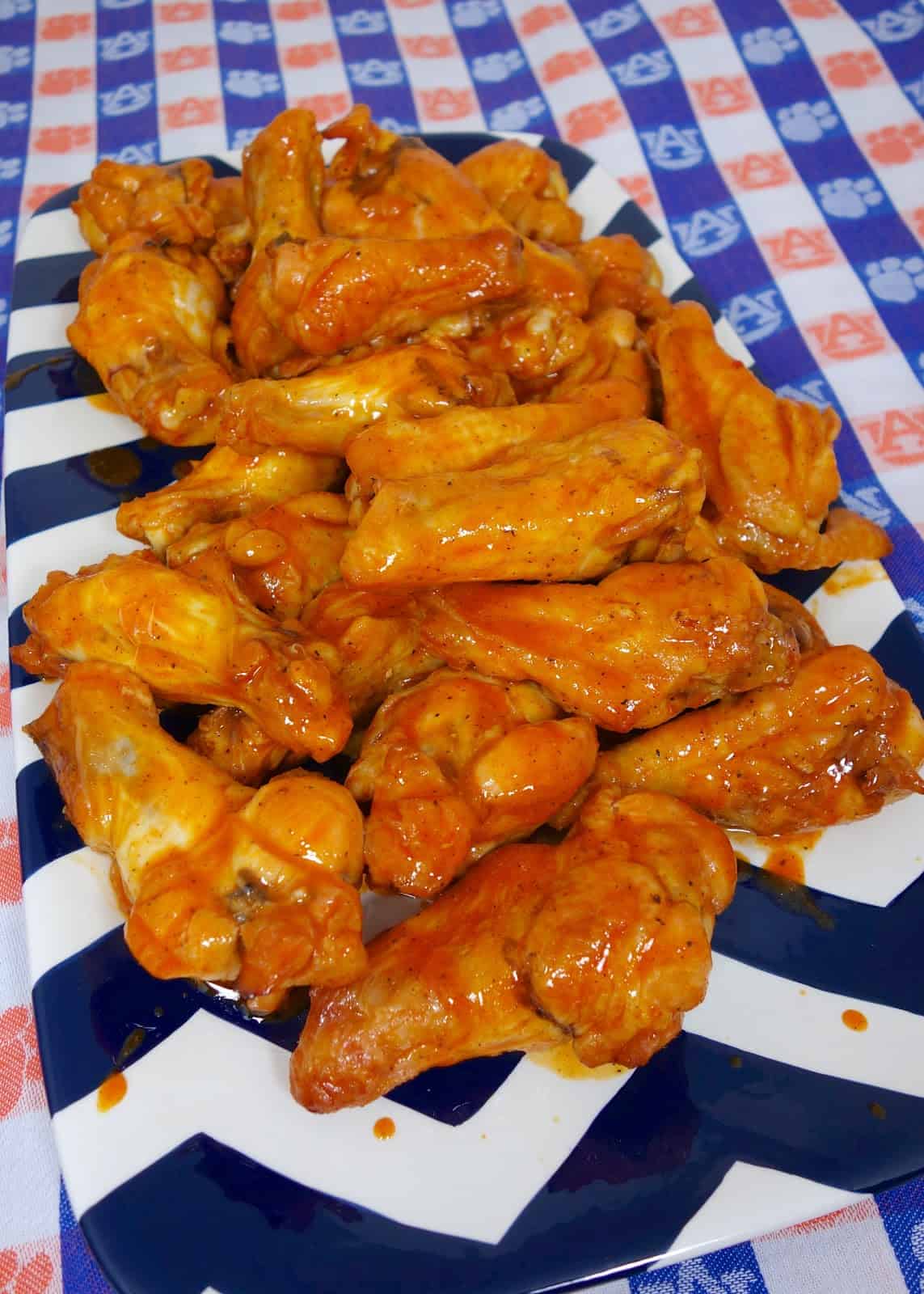 Beer Brined Chicken Wings - CRAZY delicious wings!! Baked not fried!!! Chicken wings marinated in beer, brown sugar, and salt. Bake on a rack in the oven and toss in buffalo wing sauce. Serve with ranch, bleu cheese and celery sticks. Great for parties! #chicken #tailgating #chickenwings #buffalowings