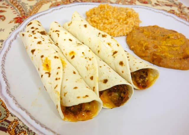 Baked Beef and Cheese Flautas - spicy taco meat and cheese baked in flour tortillas - great twist on taco night! Can assemble ahead of time and freeze for later.