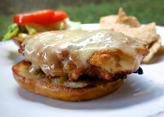 Creole Honey Mustard Chicken Sandwich Recipe - chicken marinated in dijon mustard, honey, lemon juice and cajun seasoning - grill or pan sear chicken, top with cheese and serve on a pretzel bun. This is my favorite chicken sandwich - better than any restaurant!