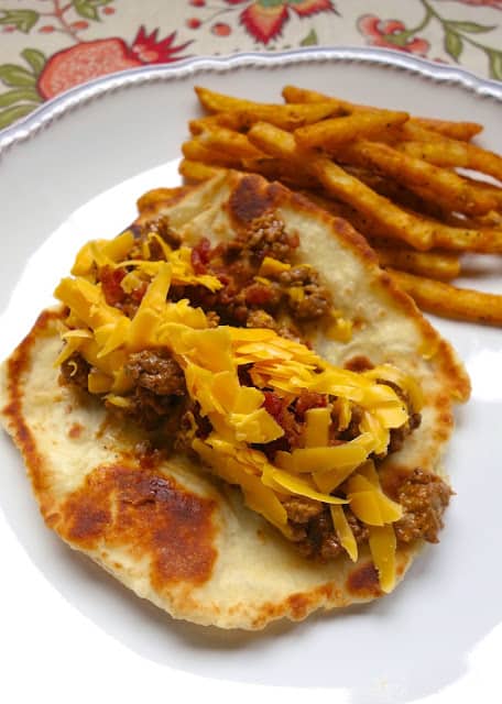 Burger night is sure to be a hit again in your house when you make this Bacon Cheeseburger Flatbread recipe - quick seasoned hamburger meat served on top of a homemade flatbread. These are SO good! The whole family gobbled them up!
