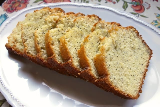 Almond Poppy Seed Bread - seriously delicious sweet bread! This recipe makes two loaves - one for you and one for a friend! Sugar, canola oil, eggs, poppy seeds, lemon juice, almond extract, vanilla, flour, baking powder, salt and milk. Top bread with a quick glaze made with powdered sugar, orange juice, vanilla and almond extract. Great for breakfast or an afternoon pick-me-up! #quickbread #sweetbread