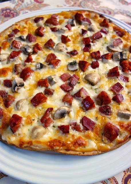 Ritz Carlton Cajun Flatbread - one of the best things we ate in NOLA! Pre-made pizza crust topped with a béchamel sauce, andouille sausage, tasso ham, mushrooms and cheese. SO good. So glad the hotel gave me the recipe!