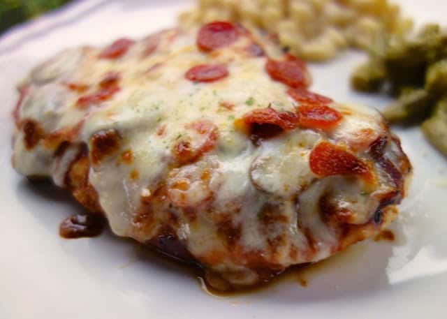 Pizza Smothered Chicken - your two favorite foods in one easy dinner! Italian marinated chicken pan seared, topped with pizza sauce, mozzarella and pizza toppings. Only 5 ingredients!! SO good! Everyone gobbled this up!! A new easy weeknight favorite!