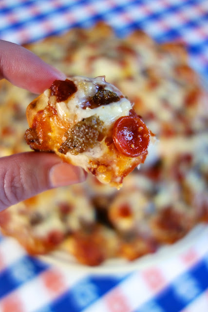 Pull-Apart Pizza Recipe - only 4 ingredients! Refrigerated pizza dough, sauce, cheese and your favorite toppings. The dough is cut into little bite size pieces and topped with the sauce, cheese, toppings and baked. This Pull-Apart Pizza is perfect for a party & tailgating! Everyone can grab a little bite-sized piece and not fill up on pizza. It is fun to eat and tastes great warm or at room temperature. It is always the first thing to go!