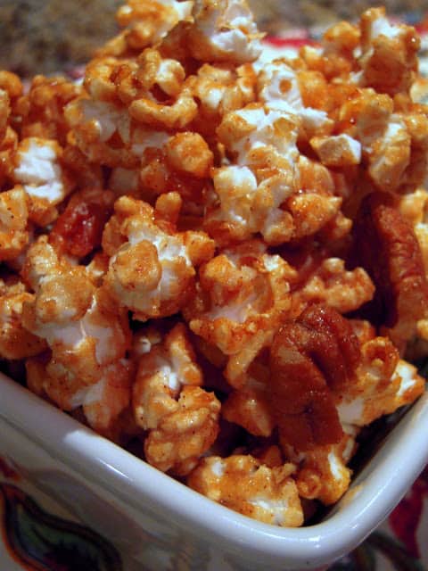 Cinnamon Caramel Corn - crazy addictive! Popcorn and pecans coated in a quick homemade cinnamon caramel sauce - brown sugar, cinnamon, corn syrup, butter, vanilla, and baking soda. Great snack or homemade gift. This always gets rave reviews! YUM!