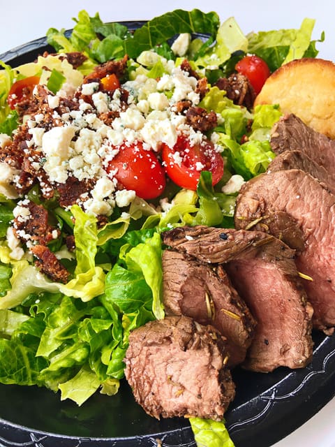 The Bistro Steak Salad at Ashely Macs in Birmingham, AL is incredible! Grilled petite tenderloin, cherry tomatoes, bleu cheese, grilled red onions, and garlic croutons. Served over a bed of mixed greens with our Balsamic vinaigrette and creamy horseradish dressing and a sour cream biscuit.