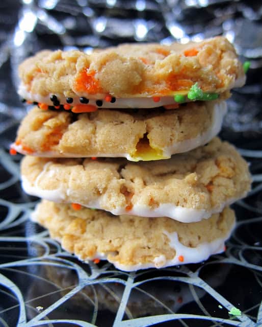 Peanut Butter Candy Corn Crunchies - peanut butter cookies with candy corn and corn flakes - dip in white chocolate and sprinkles to make extra festive!