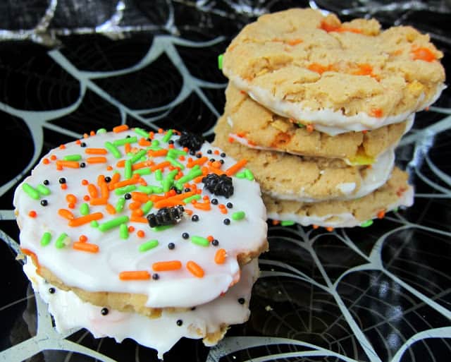 Peanut Butter Candy Corn Crunchies - peanut butter cookies with candy corn and corn flakes - dip in white chocolate and sprinkles to make extra festive!