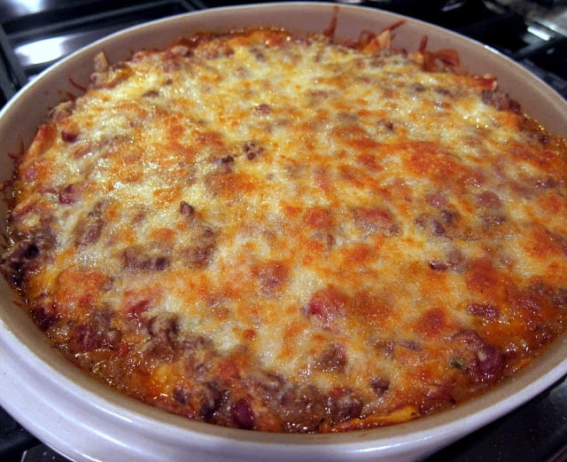 Easy 30-Minute Mexican Casserole - tortilla chips, taco meat, beans, tomatoes and cheese - top with your favorite taco toppings! Can make ahead and freeze for later. Great kid-friendly mexican recipe!!