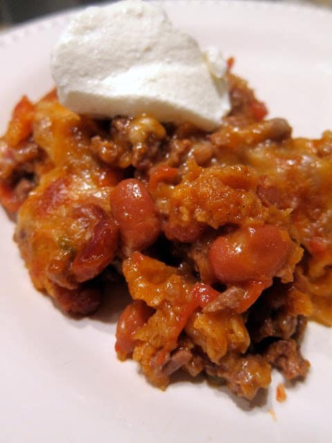 Easy 30-Minute Mexican Casserole - tortilla chips, taco meat, beans, tomatoes and cheese - top with your favorite taco toppings! Can make ahead and freeze for later. Great kid-friendly mexican recipe!!