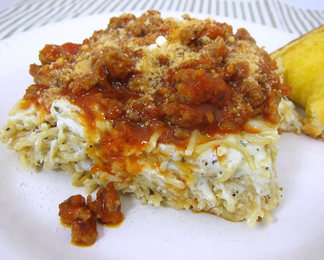 Baked Spasanga - lasagna and spaghetti in one! Baked pasta with mozzarella, ricotta, sour cream, half-and-half and parmesan. Topped with a quick meat sauce. SOOO good! Makes a great freezer meal too. Perfect for a potluck!