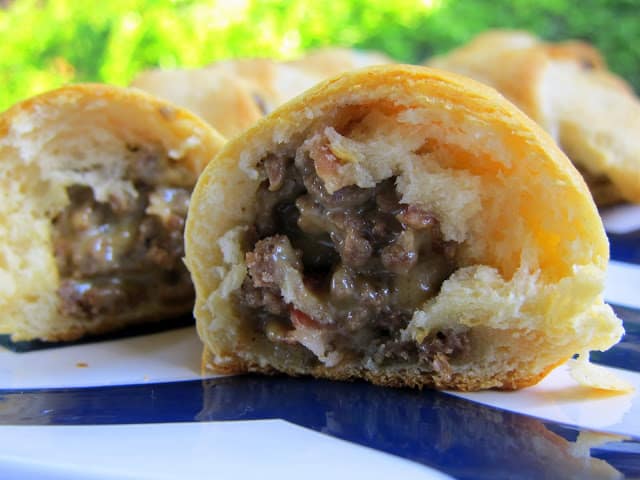 Bacon Cheeseburger Crescents - great for a quick meal or tailgating with friends!! Ground beef, bacon, Velveeta cheese, worcestershire, onions baked in crescent rolls. Seriously DELICIOUS!! Quick and easy meal. #appetizer #bacon #cheeseburger #crescentrolls #quickdinner #tailgating