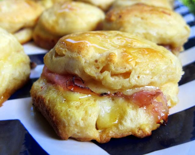 Honey Ham Biscuit Sliders Recipe - refrigerated biscuits, stuffed with ham, swiss, honey mustard and baked. Brush with honey when they are hot. SO good! Great for breakfast lunch or dinner. These are always a hit!