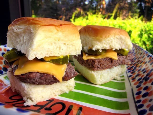Sliders - seasoned hamburger meat baked in a 9x13-inch pan and cut into squares for sliders. SO easy! Top with your favorite hamburger toppings. Great for parties!