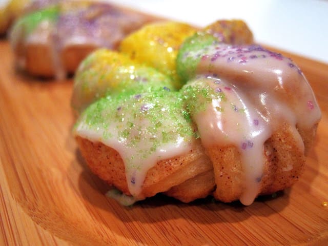 Easy King Cake Knots - refrigerated french bread dough coated in cinnamon and sugar, baked and topped with a quick homemade icing and colored sugar. Perfect for Mardi Gras!!