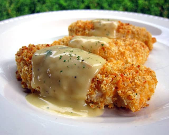 Crispy Cheddar Chicken Tenders Recipe - chicken tenders coated in cheddar, Ranch and Ritz Crackers then baked and topped with a delicious sauce. One of our all-time favorite chicken recipes. Can coat the chicken ahead of time and freeze unbaked for later. Make sauce while tenders bake. Quick and easy weeknight meal!
