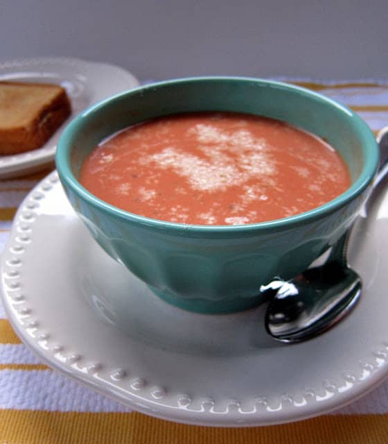 Creamy Tomato Soup recipe - delicious homemade tomato soup that is ready in under 20 minutes! Chicken broth, tomato puree, onion, garlic, red pepper flakes, oregano, basil, cream cheese and milk. I use low fat cheese and milk and it tastes great!! Serve with a grilled cheese sandwich for a quick weeknight meal.