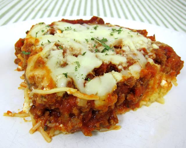 Delicious Baked Spaghetti Casserole - spaghetti, egg, parmesan, cottage cheese, sausage/hamburger, crushed tomatoes, tomato paste, spices and mozzarella - SOOO good! Baked pasta topped with a quick homemade sauce. Makes a great freezer meal!