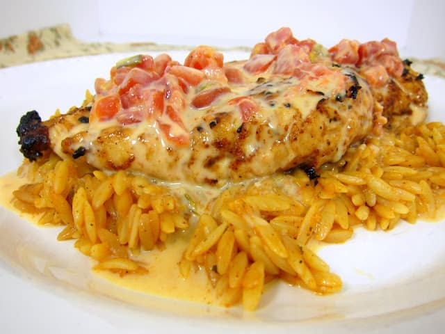 Queso Smothered Chicken - Tex-Mex grilled chicken smothered in Queso and served over southwest seasoned orzo. SO quick and easy to make.This chicken is AMAZING! I wanted to lick my plate!!! 
