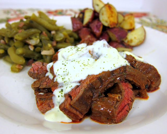 Buffalo Style Skirt Steak with Bleu Cheese Sauce recipe - skirt steak marinated in hot sauce, grilled and topped with a homemade bleu cheese sauce - SO good. Ready in under 20 minutes. Serve with some green beans and potatoes.