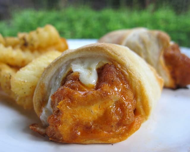 Buffalo Chicken Crescents - quick recipe for a weeknight meal or quick lunch. Also great at parties! Frozen chicken tenders, buffalo sauce, cheddar cheese, Ranch dressing baked in refrigerated crescent rolls. Serve with fries for a quick dinner! SO good!!