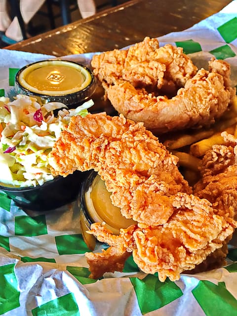 The Chicken Tenders at Beef O'Brady's in Birmingham, AL are surprisingly good. Real chicken battered and fried. It comes with slaw and fries. It is definitely enough to share!