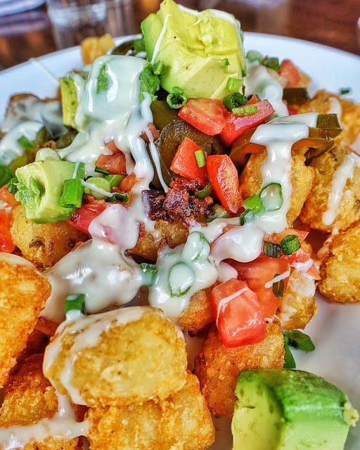 Tater Tot Nachos at The Flipside in Nashville's 12 South neighborhood - tater tots topped with queso, avocado, tomatoes, bacon, jalapeños and green onions. YUM!