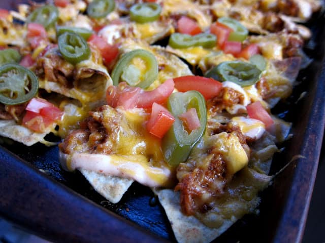 Game Day BBQ Pork Nachos Recipe - BBQ Pork, Cheese, Sour Cream, Tomatoes, Jalapeños and Tortilla Chips - Quick Recipe for a party! These are always gone in a flash!