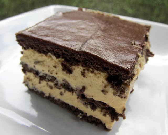 No-Bake Peanut Butter Eclair Cake Recipe - peanut butter pudding, cool whip and chocolate graham crackers layered and topped with chocolate frosting. It gets better the longer it sits in the fridge - it is just SO hard to wait to eat it. SOOO good. People go nuts over this easy dessert recipe!
