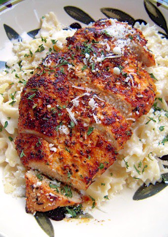 Blackened Chicken with Roasted Garlic Alfredo - so simple and SO delicious!! Chicken rubbed with cajun seasoning and pan seared. Serve over bowtie pasta tossed in roasted garlic and alfredo sauce. Better than any restaurant! Ready in under 20 minutes!!