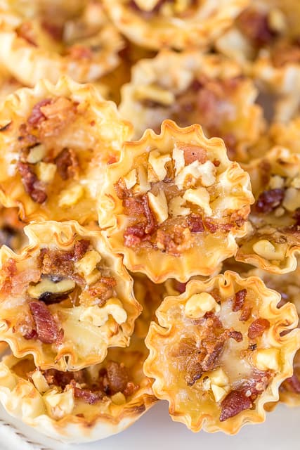Honey Bacon Walnut and Brie Bites recipe - sweet and salty goodness!!! The flavor combination is totally addicting. Can make the bites ahead of time and refrigerate until ready to bake. Great for all your holiday parties and tailgating!! You might want to double the recipe - these cheese bites don't last long!! #appetizer #holidayappetizer #brie #cheese